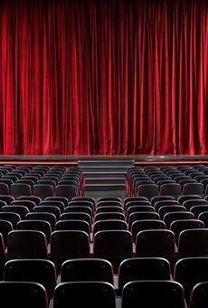teatro vuoto con sedie rosse vuote verso un palcoscenico